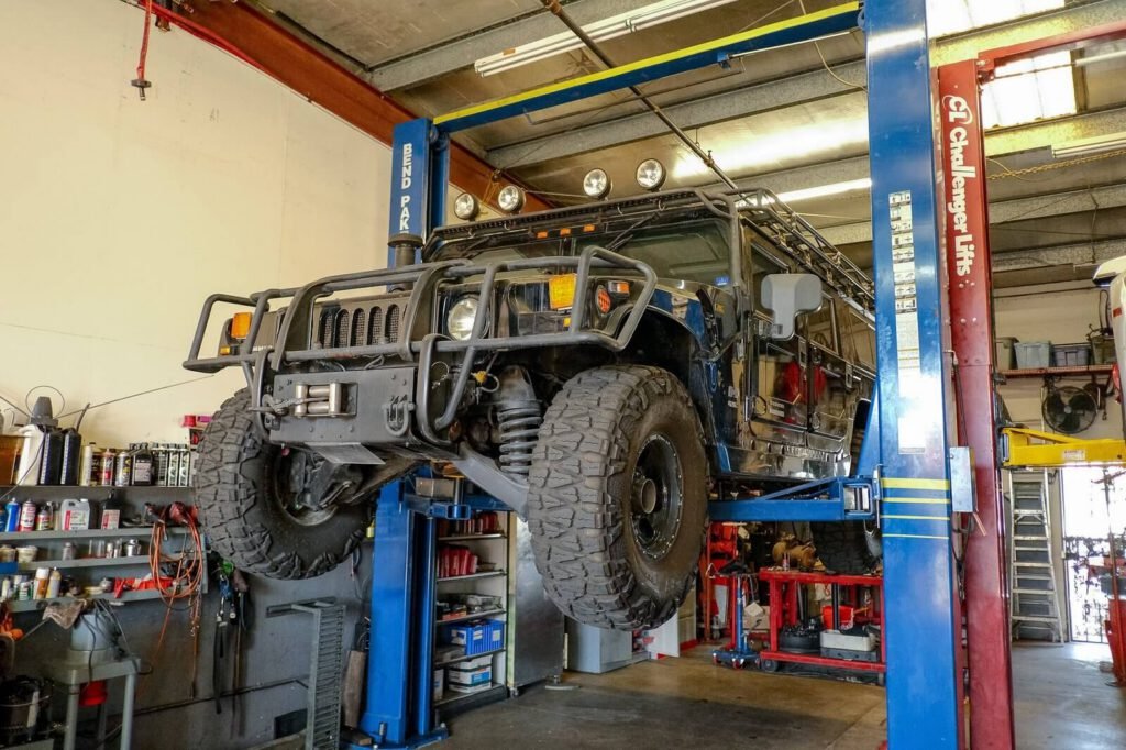 A hummer is lifted inside the shop for a specialized repair.